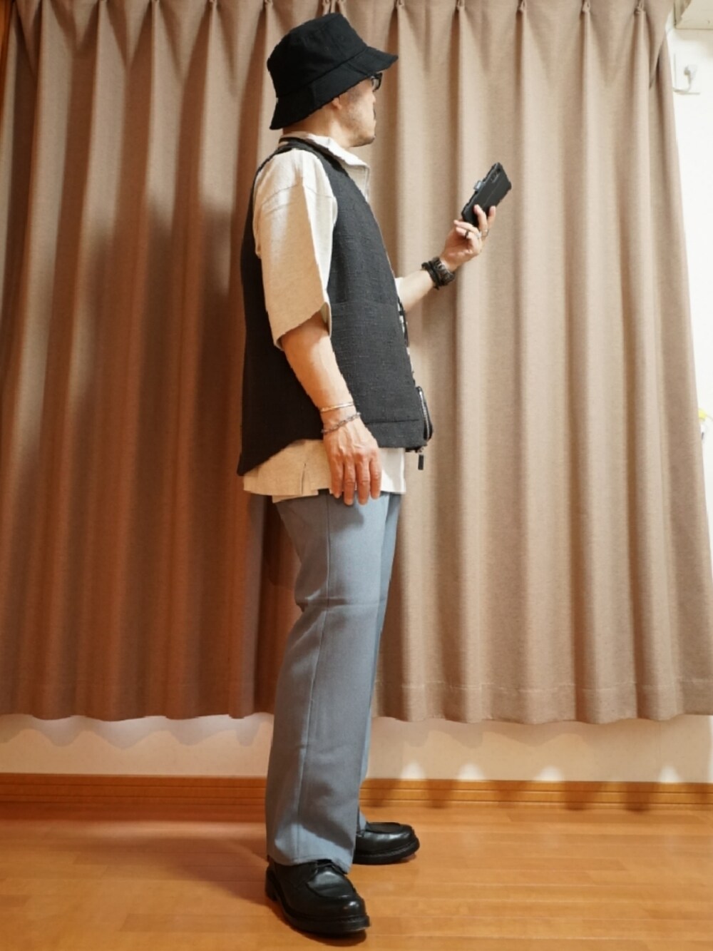 ブルー系のパンツ、ホワイト系のタンクトップ、ブラック系のショルダーバッグを着用したメンズの夏コーディネートの4枚目の写真