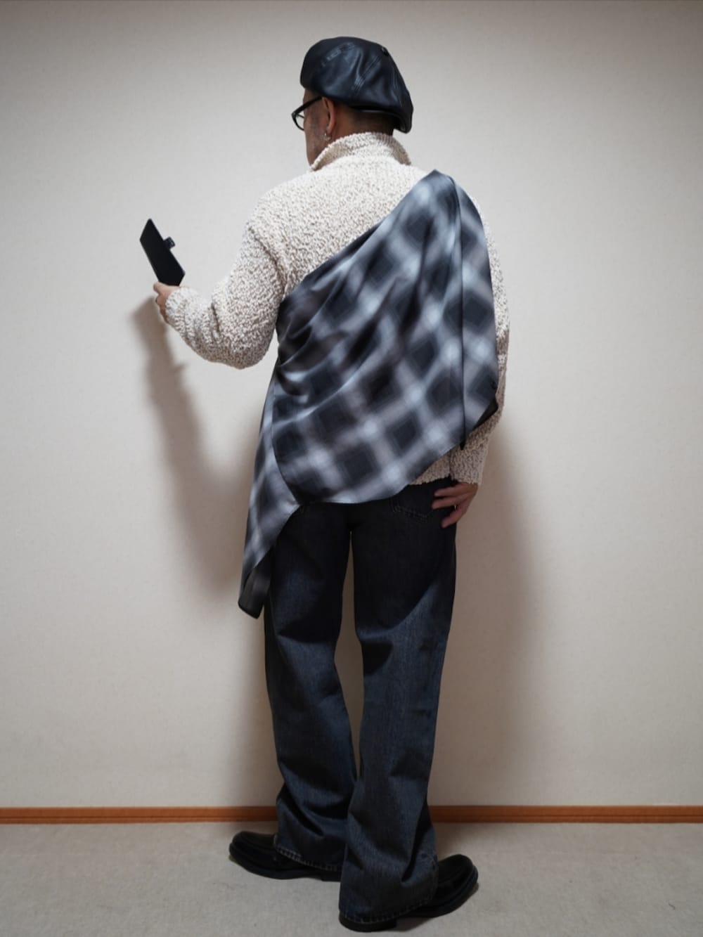 ブラック系のシューズ、ブルー系のデニムパンツ、ホワイト系のニット/セーターを着用したメンズの春コーディネートの5枚目の写真