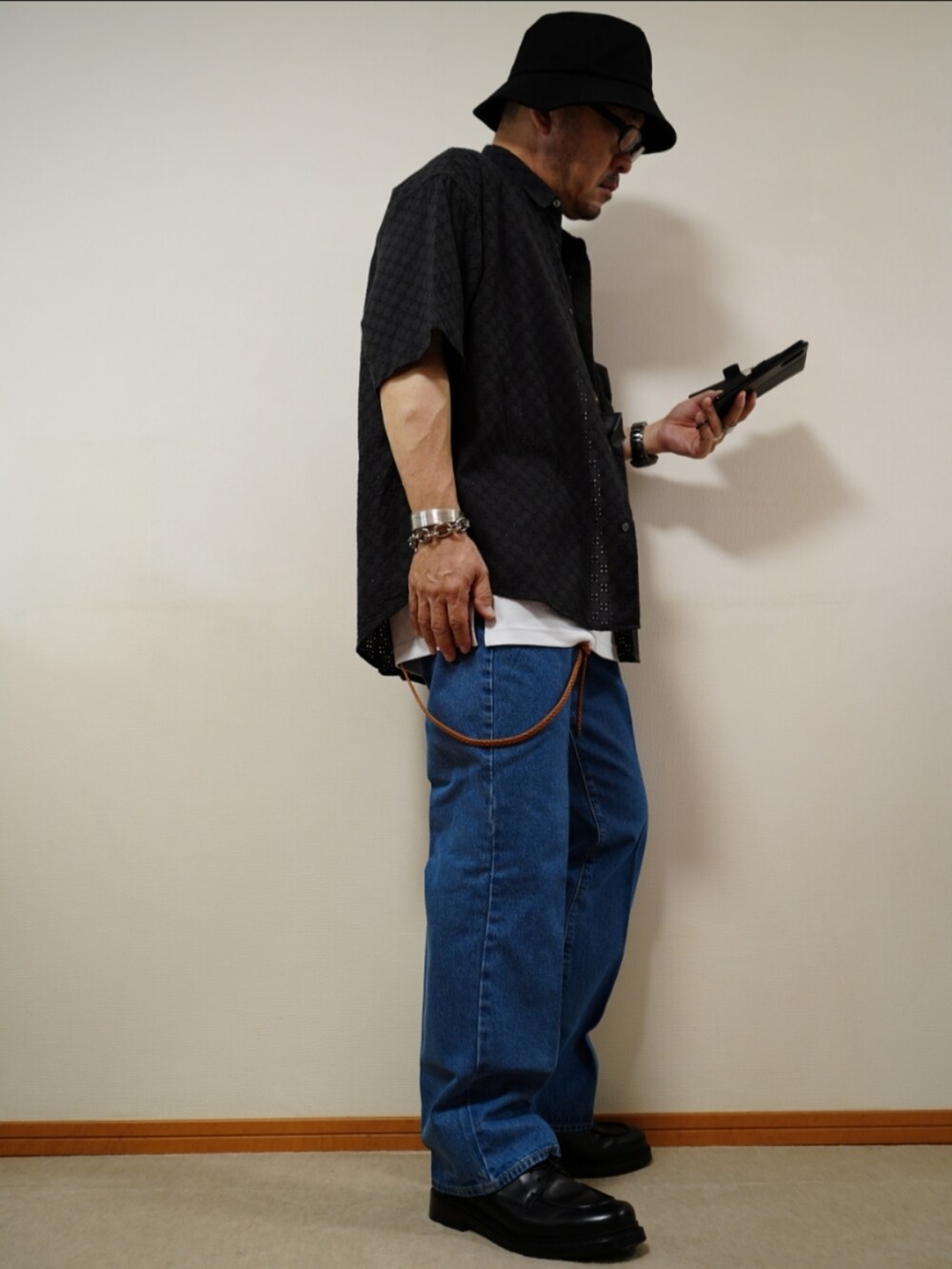 ブラック系のシューズ、ブルー系のデニムパンツ、ホワイト系のタンクトップを着用したメンズの夏コーディネートの4枚目の写真