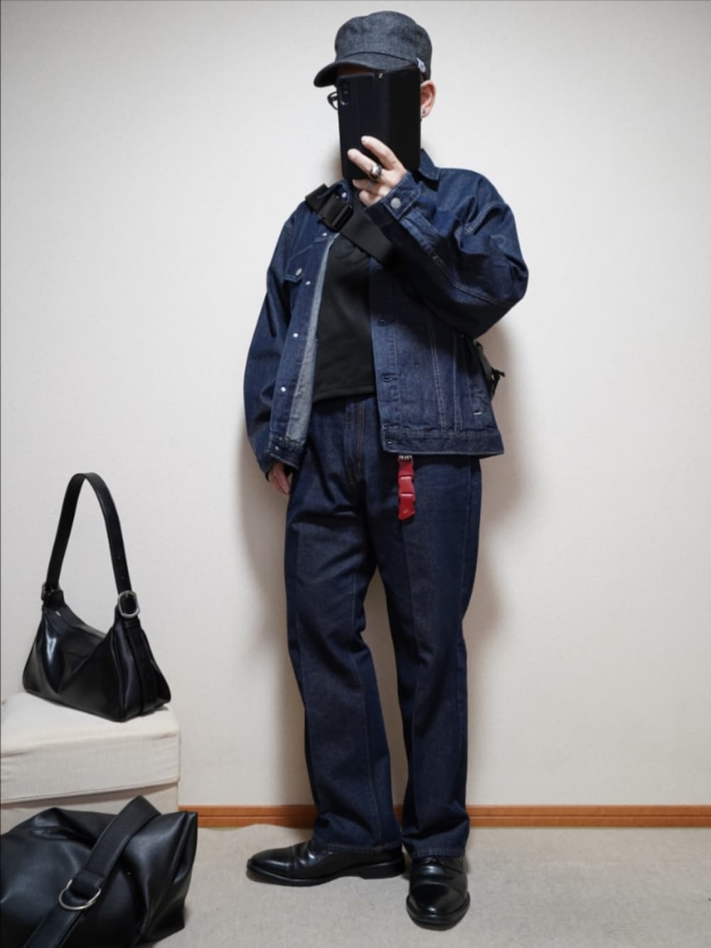 ブラック系のドレスシューズ、ブルー系のデニムパンツ、ブラック系のTシャツ/カットソーを着用したメンズの春コーディネートの2枚目の写真