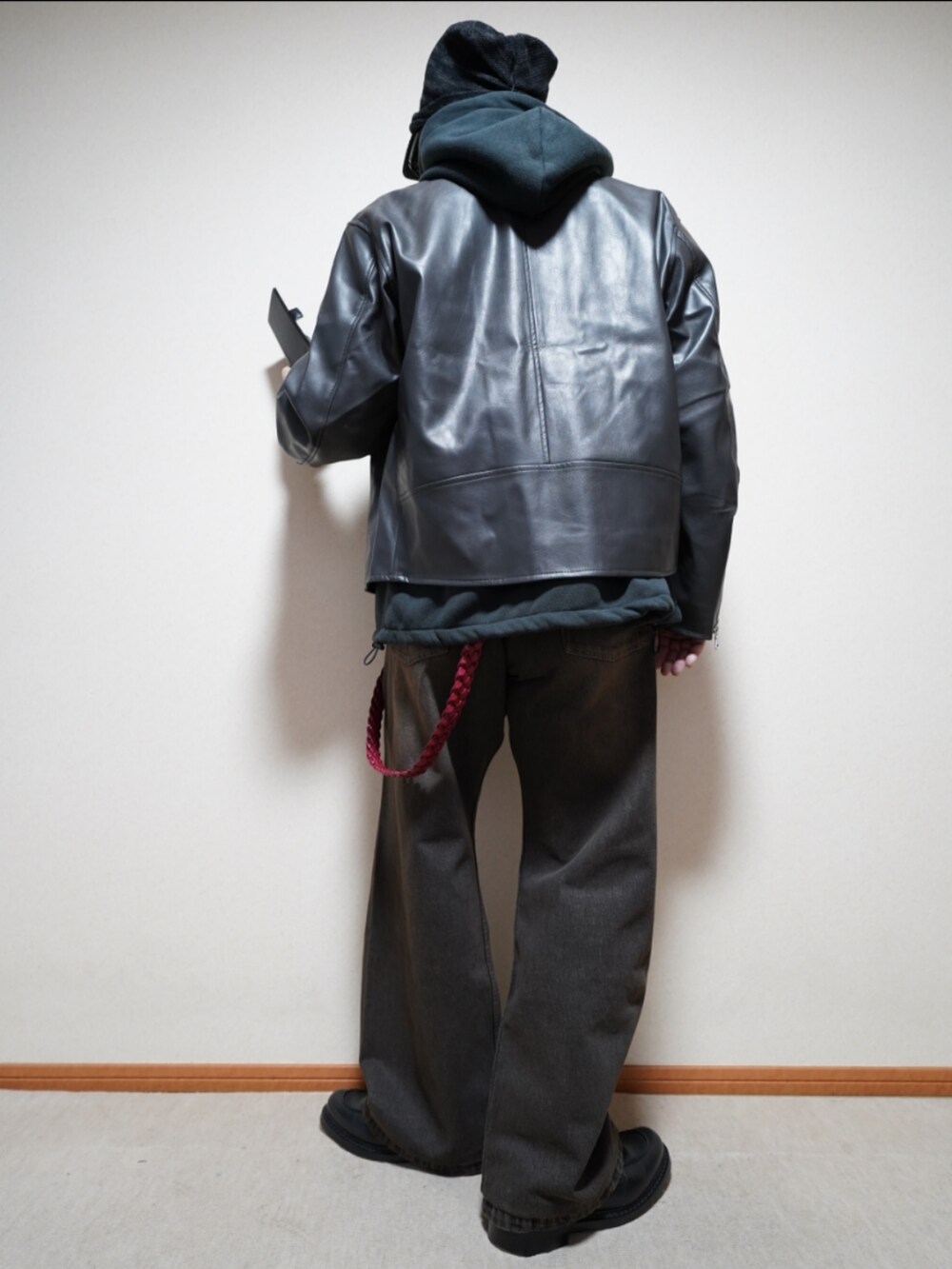 ブラック系のシューズ、ブラック系のパーカー、グレー系のライダースジャケットを着用したメンズの冬コーディネートの4枚目の写真
