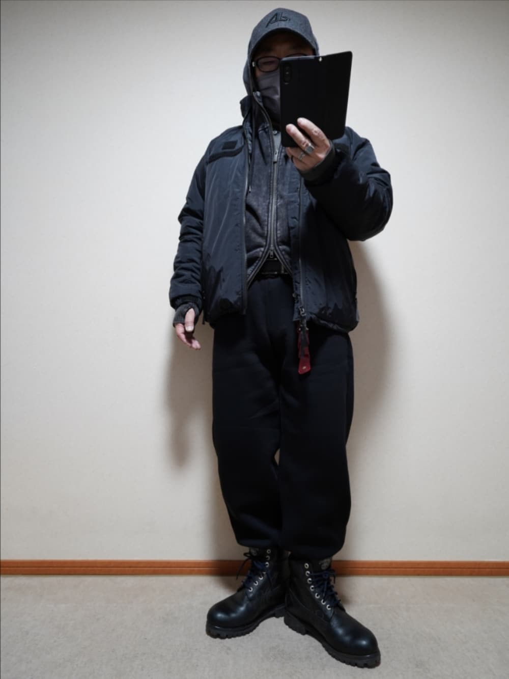 ブラック系のブーツ、ブラック系のスウェットパンツ、ブラック系のパーカーを着用したメンズの冬コーディネートの2枚目の写真