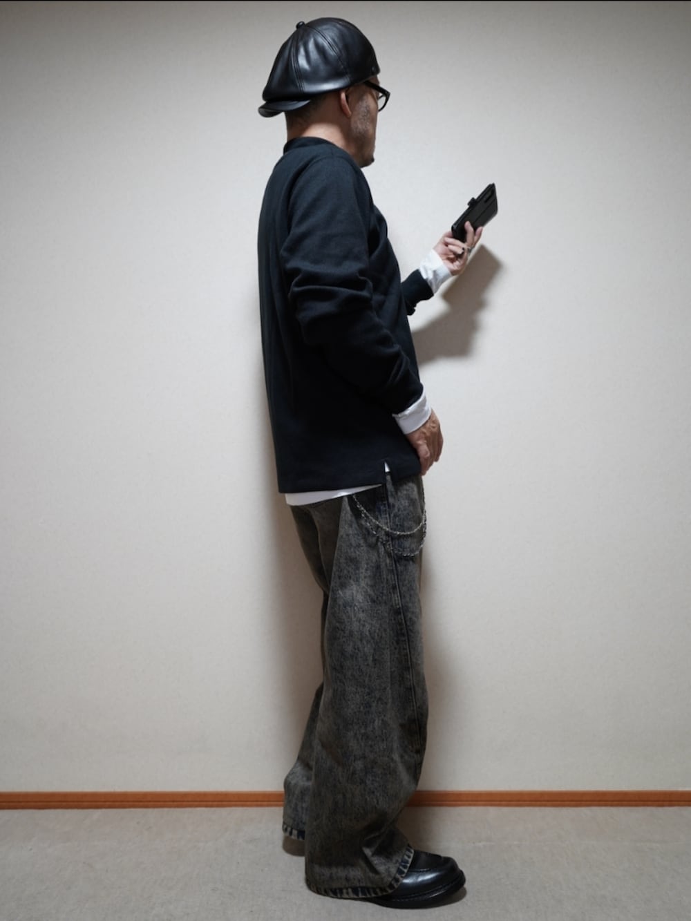 ブラック系のシューズ、ブルー系のデニムパンツ、ブラック系のトップスを着用したメンズの春コーディネートの4枚目の写真