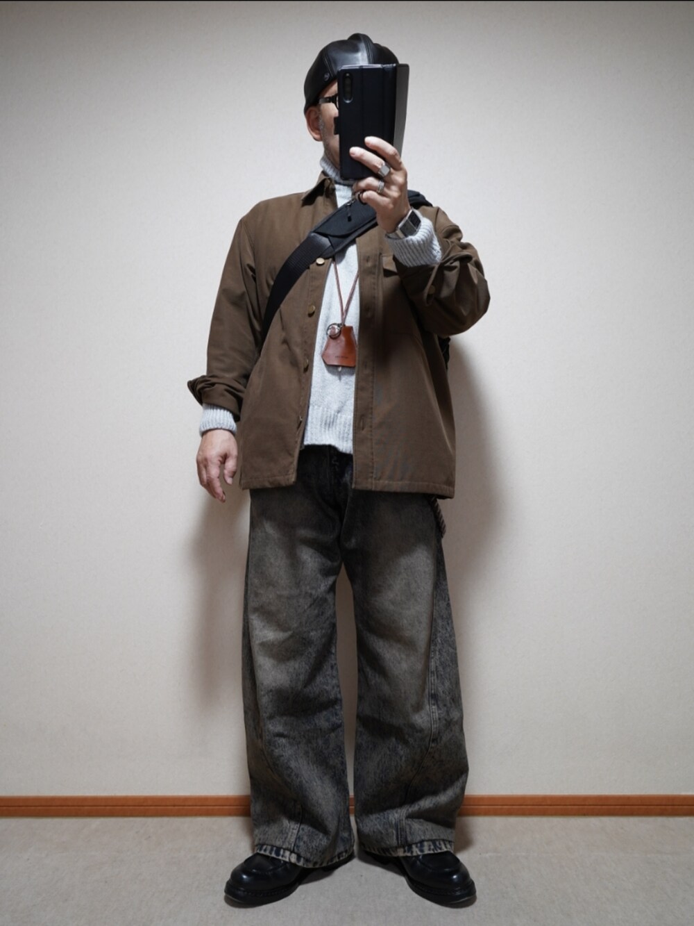 ブラック系のシューズ、ブルー系のデニムパンツ、グレー系のトップスを着用したメンズの冬コーディネートの2枚目の写真