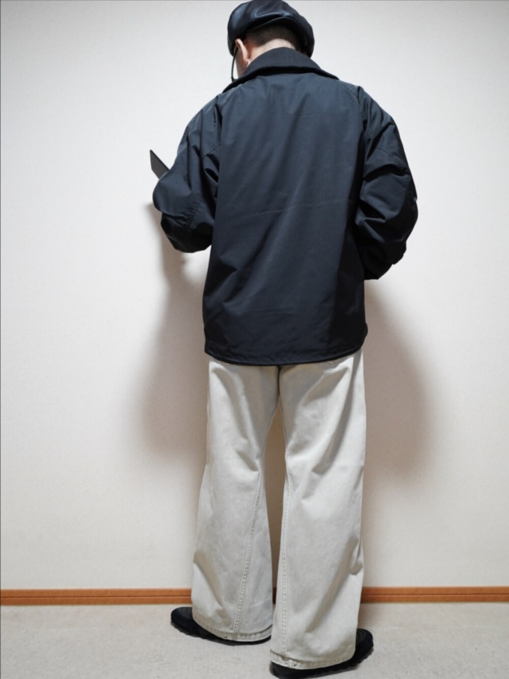 ブラック系のスニーカー、ベージュ系のデニムパンツ、ブラック系のブルゾンを着用したメンズの秋コーディネートの4枚目の写真