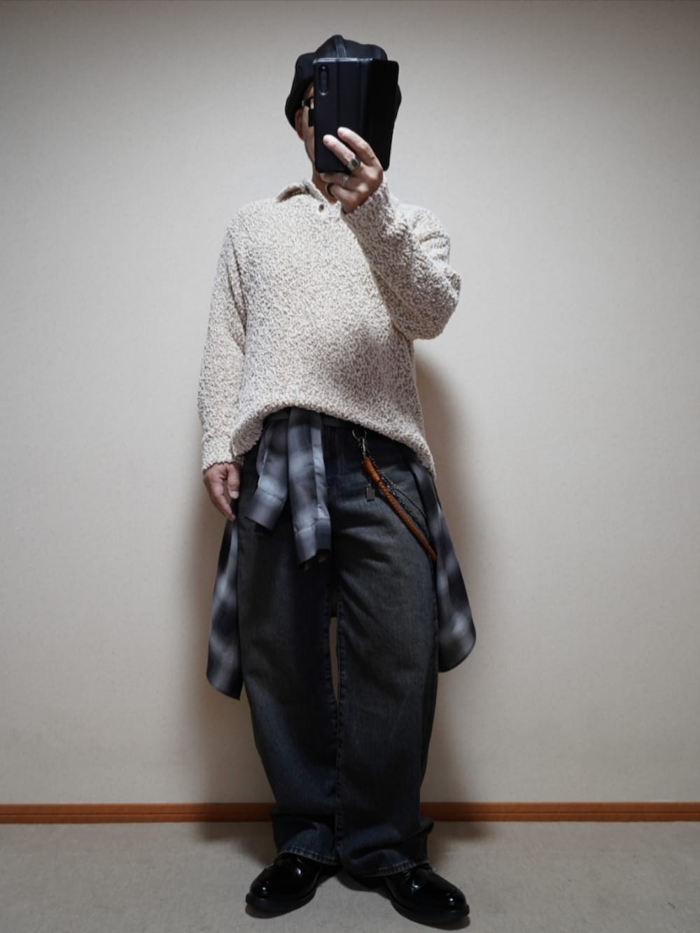 ブラック系のシューズ、ブルー系のデニムパンツ、ホワイト系のニット/セーターを着用したメンズの春コーディネートの2枚目の写真