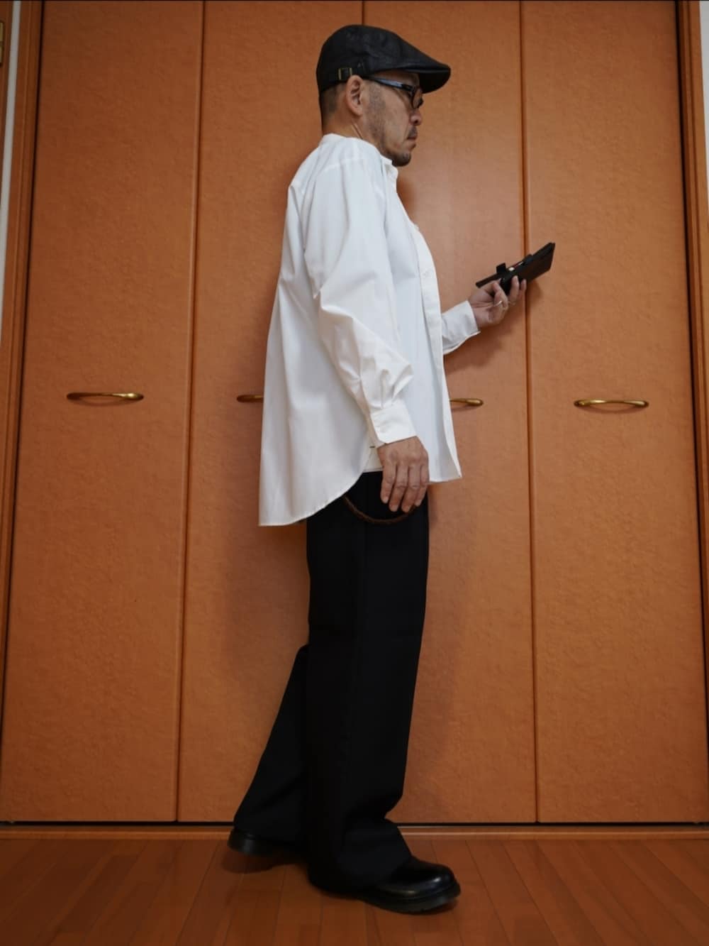 ブラック系のパンツ、ホワイト系のシャツ/ブラウス、ブラック系のシューズを着用したメンズの秋コーディネートの4枚目の写真
