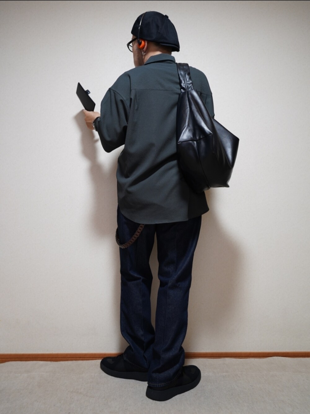 ブラック系のスニーカー、ブルー系のデニムパンツ、グレー系のタンクトップを着用したメンズの夏コーディネートの3枚目の写真