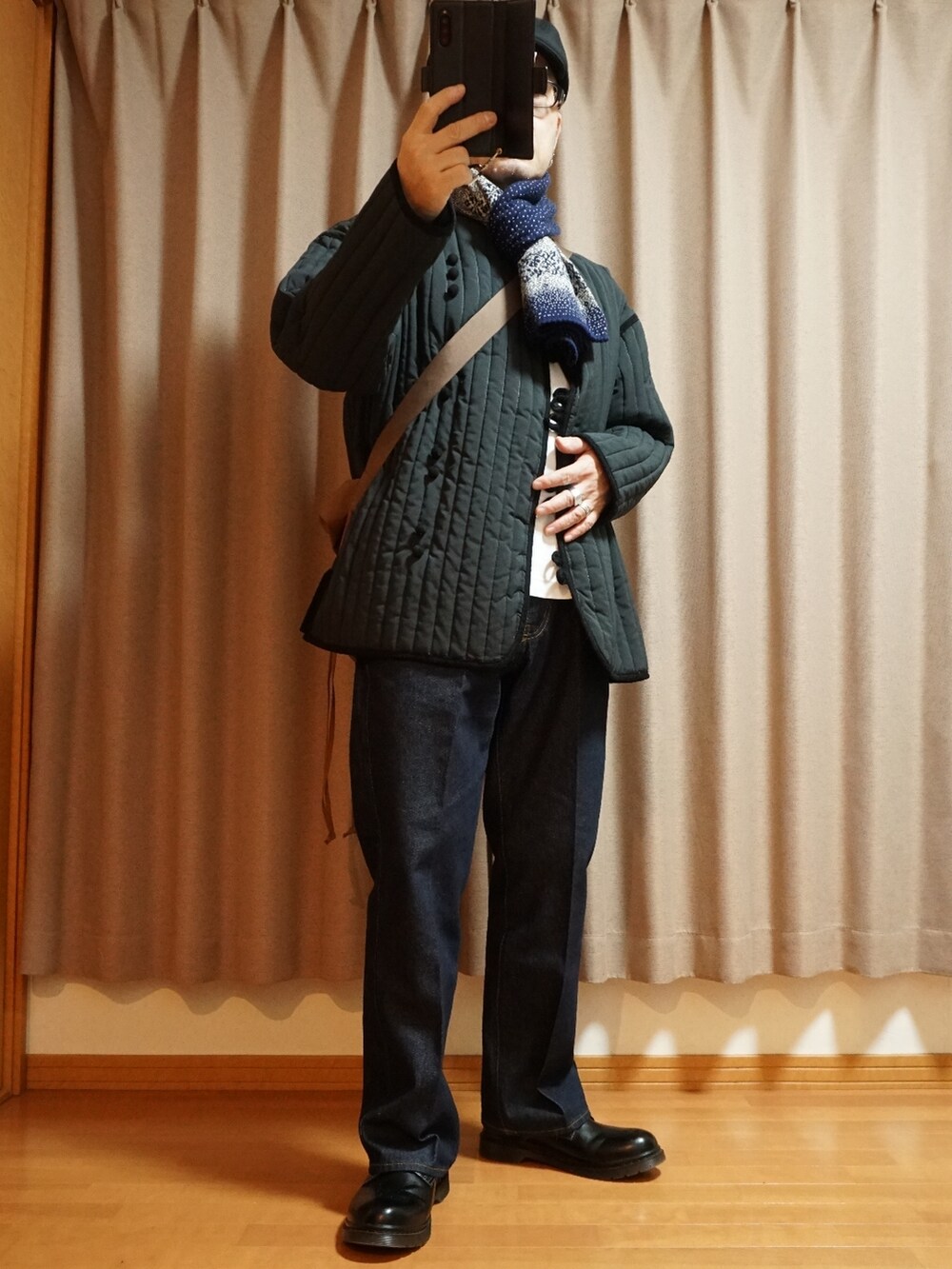 ブラック系のシューズ、ブルー系のデニムパンツ、ブラック系のミリタリージャケットを着用したメンズの秋コーディネートの5枚目の写真