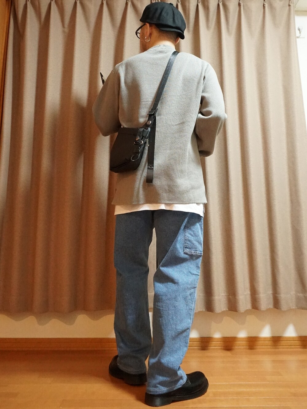 ブラック系のシューズ、ブルー系のデニムパンツ、グレー系のニット/セーターを着用したメンズの夏コーディネートの3枚目の写真