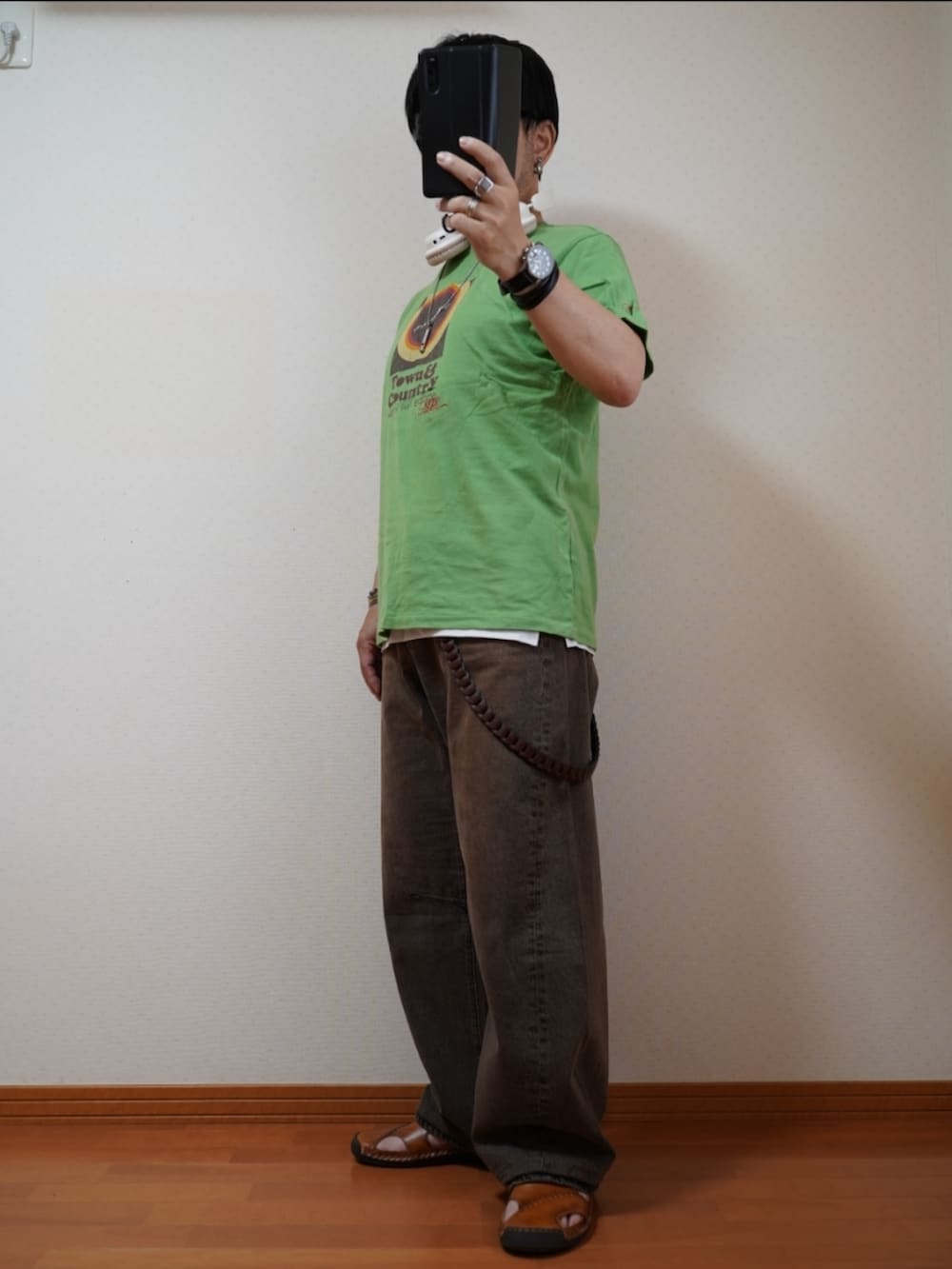 ブラック系のサンダル、ブラウン系のデニムパンツ、グリーン系のTシャツ/カットソーを着用したメンズの夏コーディネートの3枚目の写真