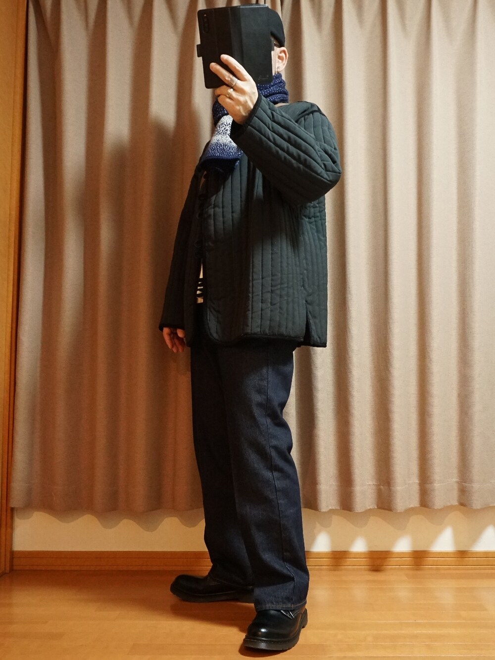 ブラック系のシューズ、ブルー系のデニムパンツ、ブラック系のミリタリージャケットを着用したメンズの秋コーディネートの2枚目の写真