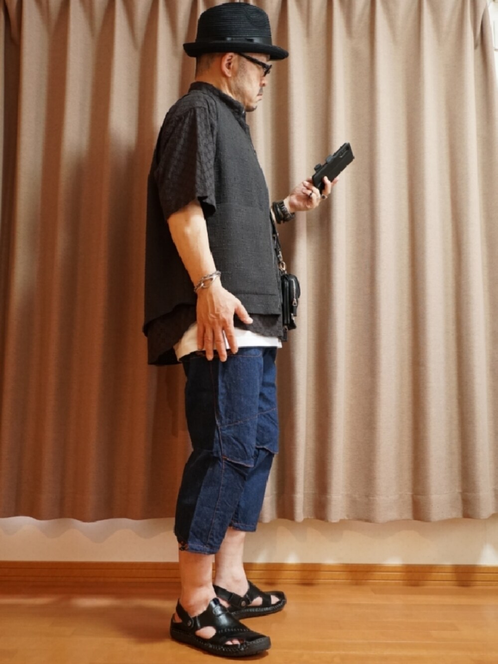 ブラック系のサンダル、ブルー系のデニムパンツ、ホワイト系のタンクトップを着用したメンズの夏コーディネートの4枚目の写真