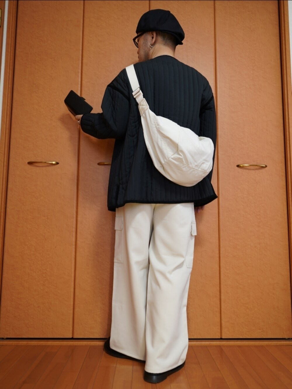 ブラック系のシューズ、グレー系のTシャツ/カットソー、ホワイト系のショルダーバッグを着用したメンズの秋コーディネートの3枚目の写真