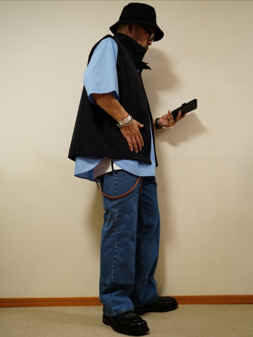 ブラック系のシューズ、ブルー系のデニムパンツ、ホワイト系のタンクトップを着用したメンズの夏コーディネートの4枚目の写真