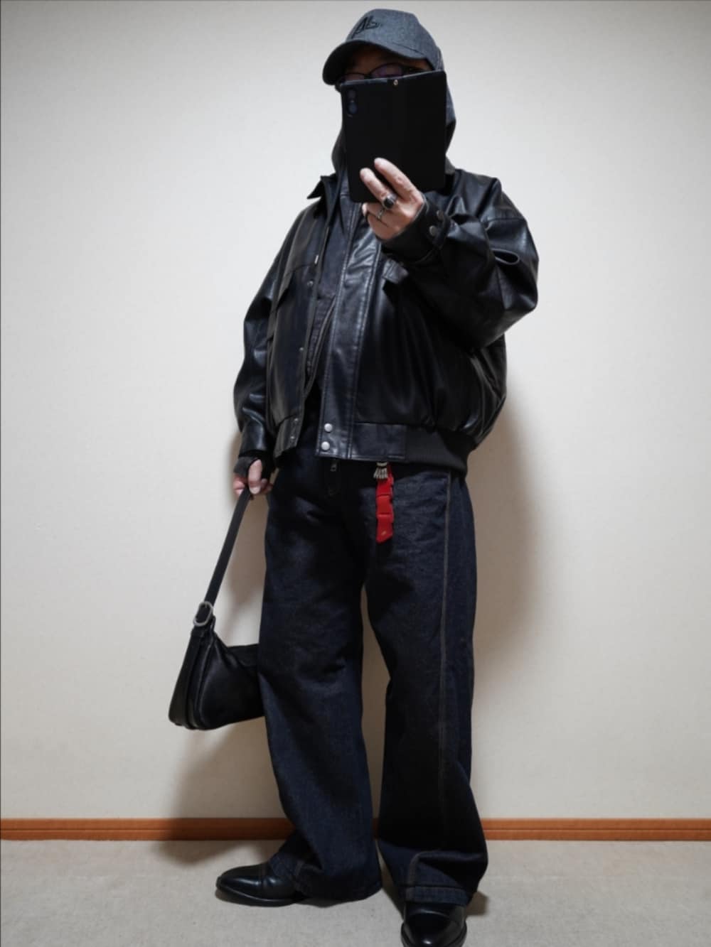 ブラック系のドレスシューズ、ブルー系のデニムパンツ、ブラック系のショルダーバッグを着用したメンズの冬コーディネートの2枚目の写真