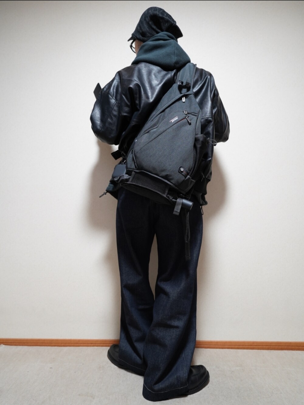 ブラック系のシューズ、ブルー系のデニムパンツ、ブラック系のパーカーを着用したメンズの冬コーディネートの2枚目の写真