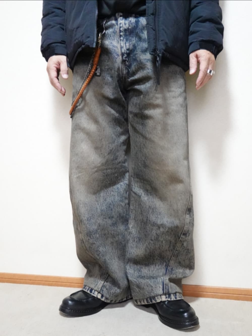 ブラック系のシューズ、ブルー系のデニムパンツ、ブラック系のダウンジャケット/コートを着用したメンズの秋コーディネートの5枚目の写真