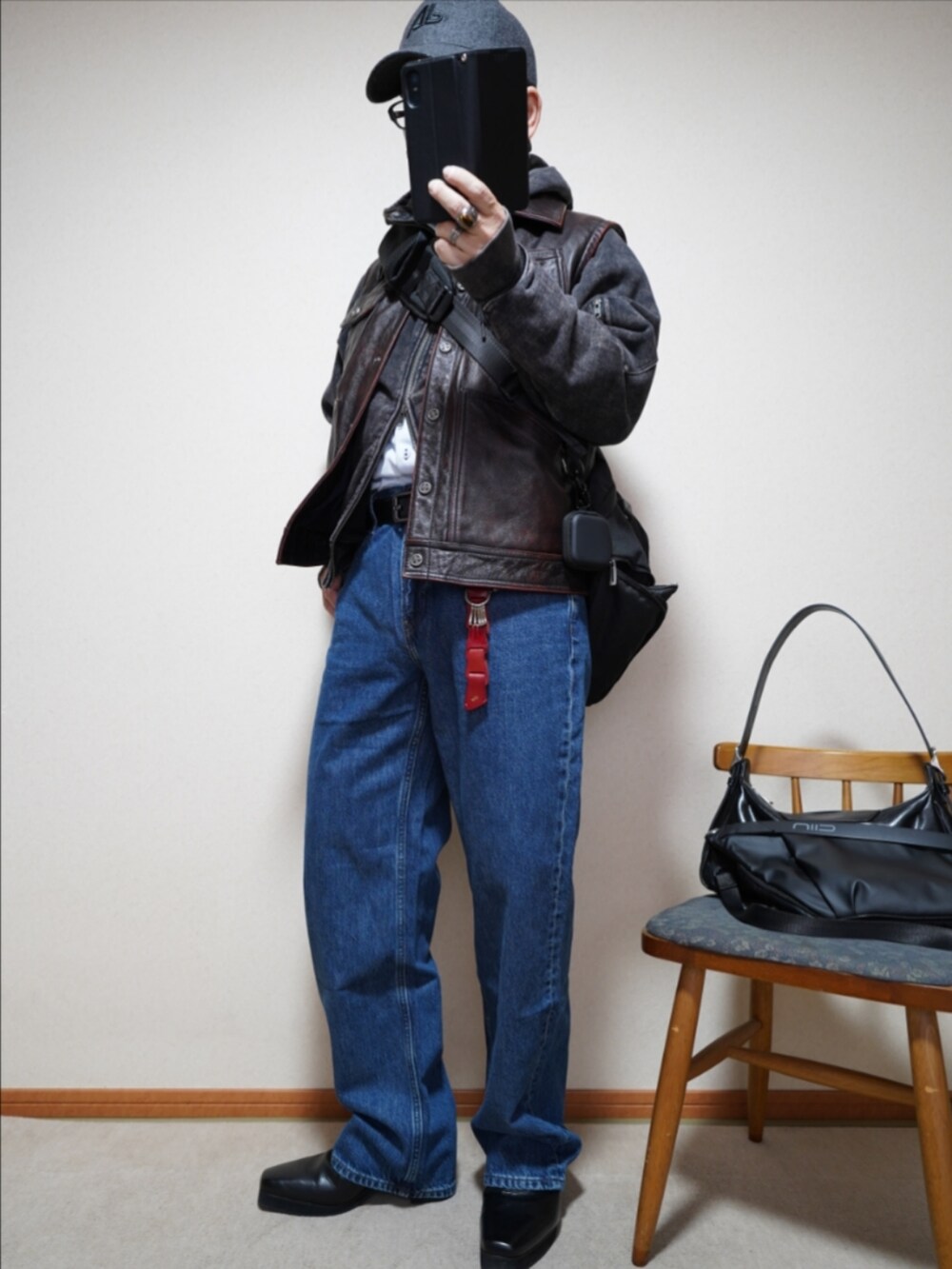 ブラック系のブーツ、ブルー系のデニムパンツ、ブラック系のパーカーを着用したメンズの春コーディネートの2枚目の写真