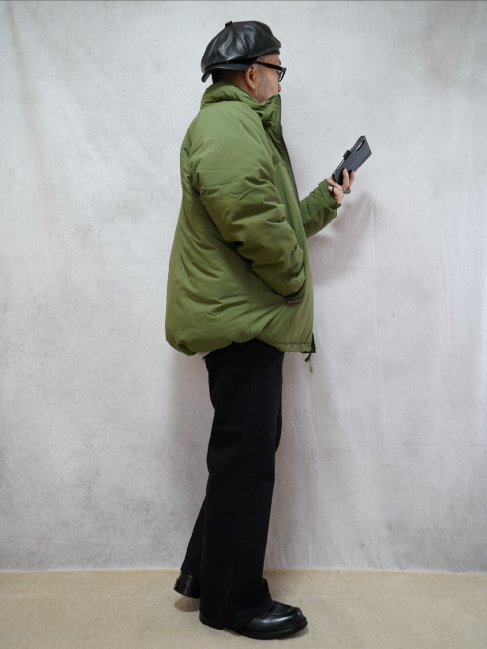 ブラック系のシューズ、グレー系のデニムパンツ、グリーン系のダウンジャケット/コートを着用したメンズの冬コーディネートの4枚目の写真