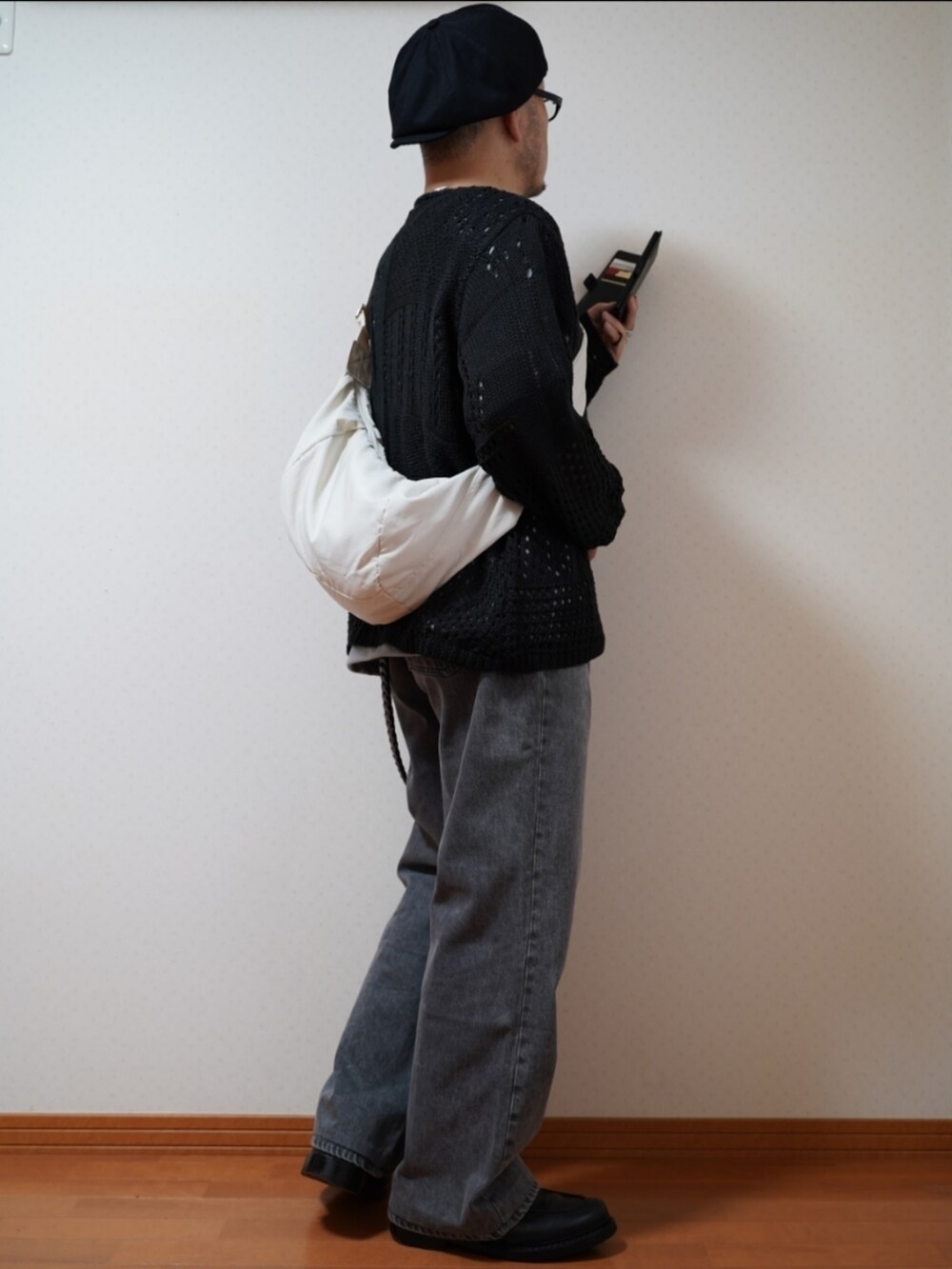 ブラック系のシューズ、グレー系のデニムパンツ、ブラック系のニット/セーターを着用したメンズの夏コーディネートの4枚目の写真