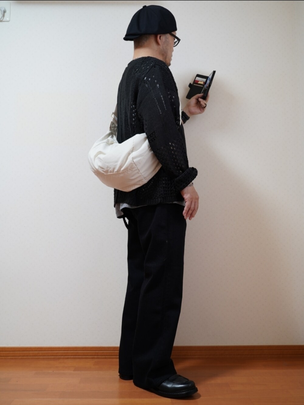 ブラック系のシューズ、グレー系のデニムパンツ、ブラック系のニット/セーターを着用したメンズの夏コーディネートの5枚目の写真