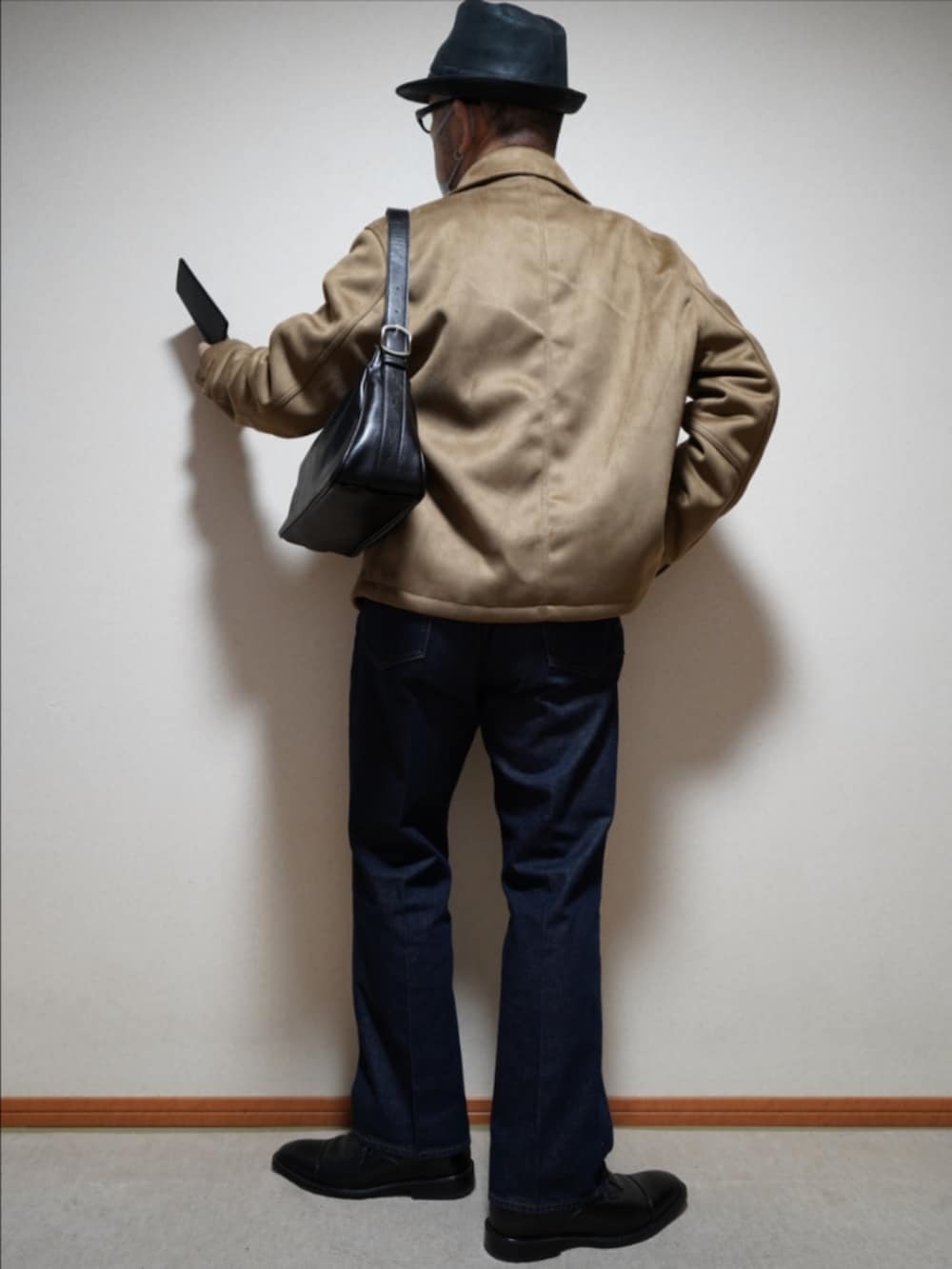 ブラック系のドレスシューズ、ブルー系のデニムパンツ、ブラウン系のカーディガン/ボレロを着用したメンズの冬コーディネートの4枚目の写真