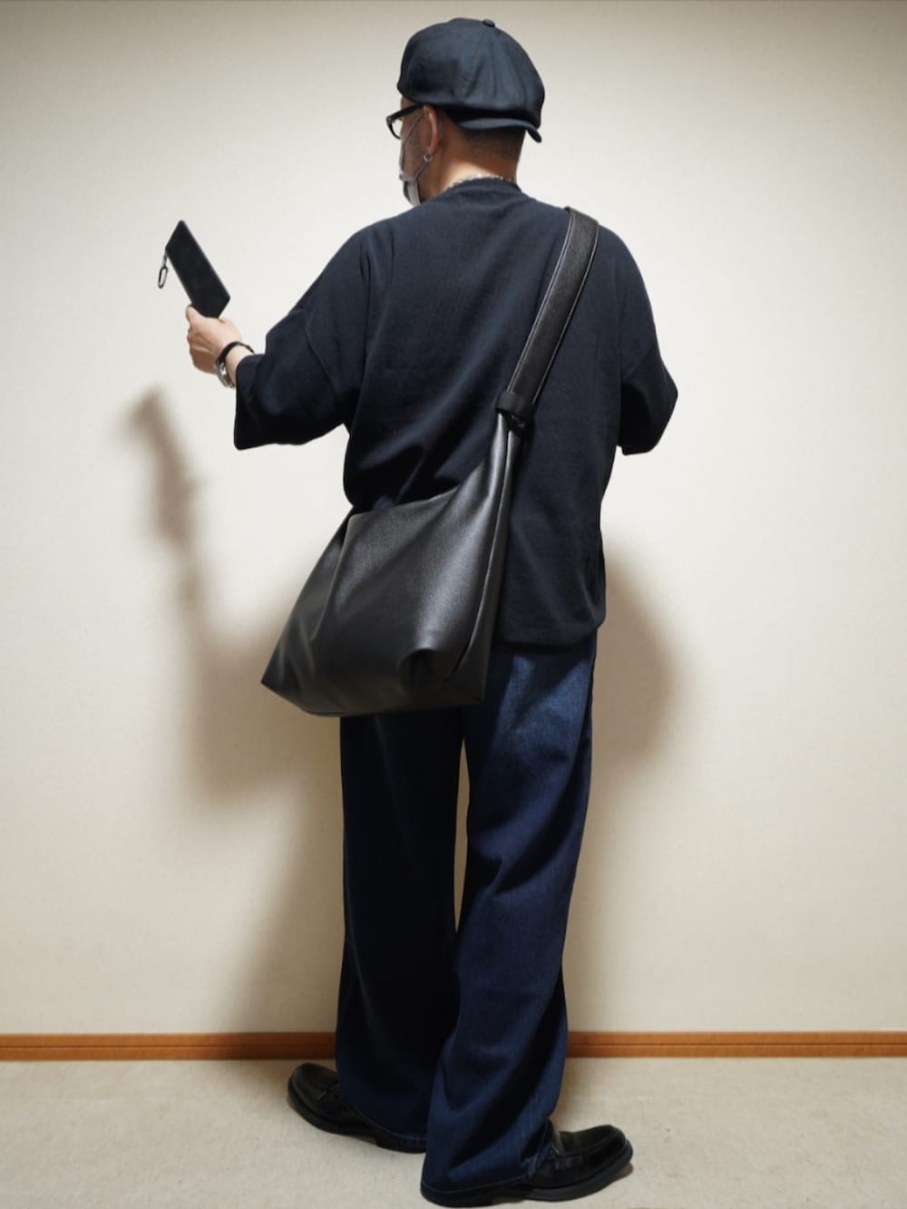 ブラック系のシューズ、ブルー系のデニムパンツ、ブラック系のTシャツ/カットソーを着用したメンズの夏コーディネートの3枚目の写真