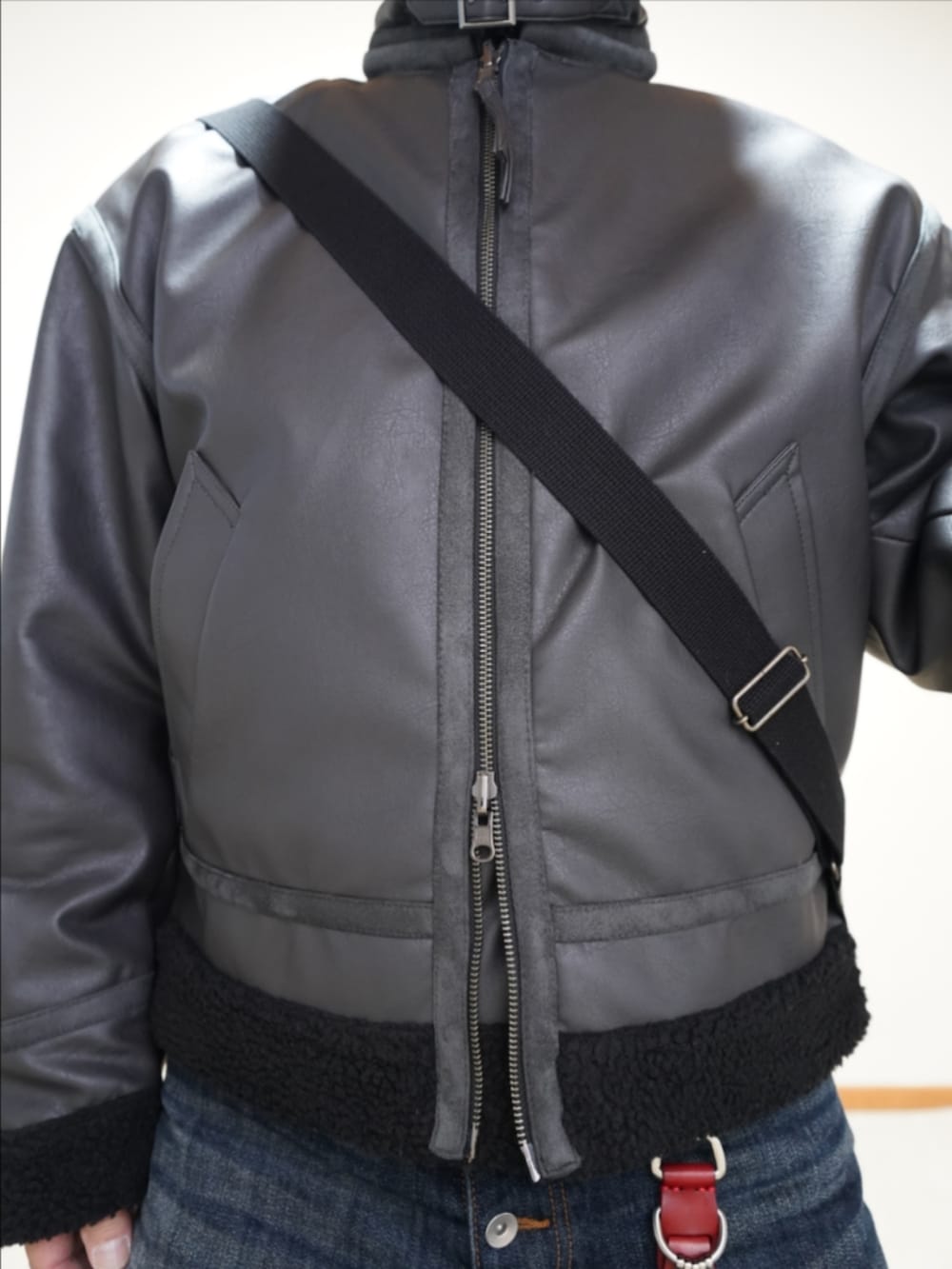 ブラック系のドレスシューズ、ブルー系のデニムパンツ、グレー系のブルゾンを着用したメンズの冬コーディネートの4枚目の写真