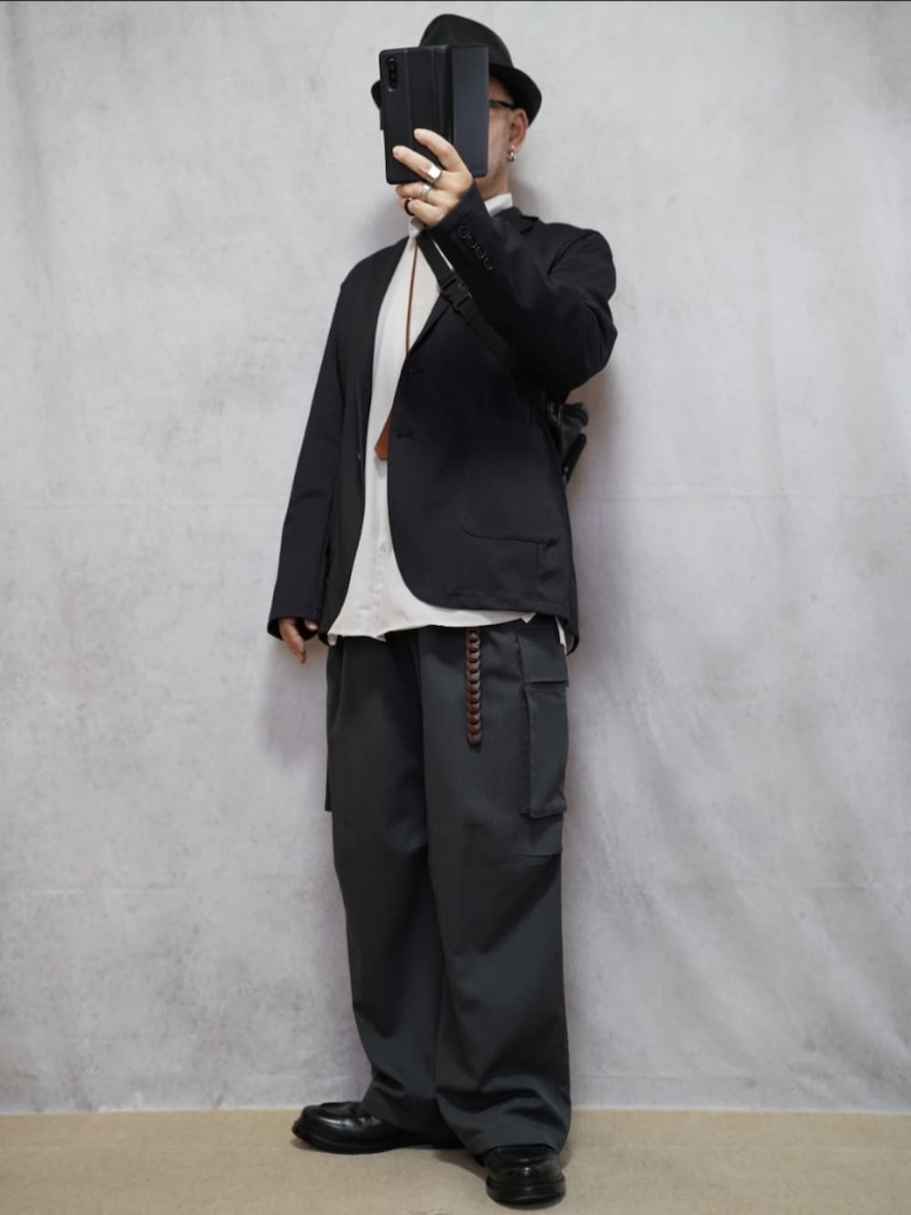 ブラック系のシューズ、グレー系のカーゴパンツ、ホワイト系のシャツ/ブラウスを着用したメンズの春コーディネートの2枚目の写真