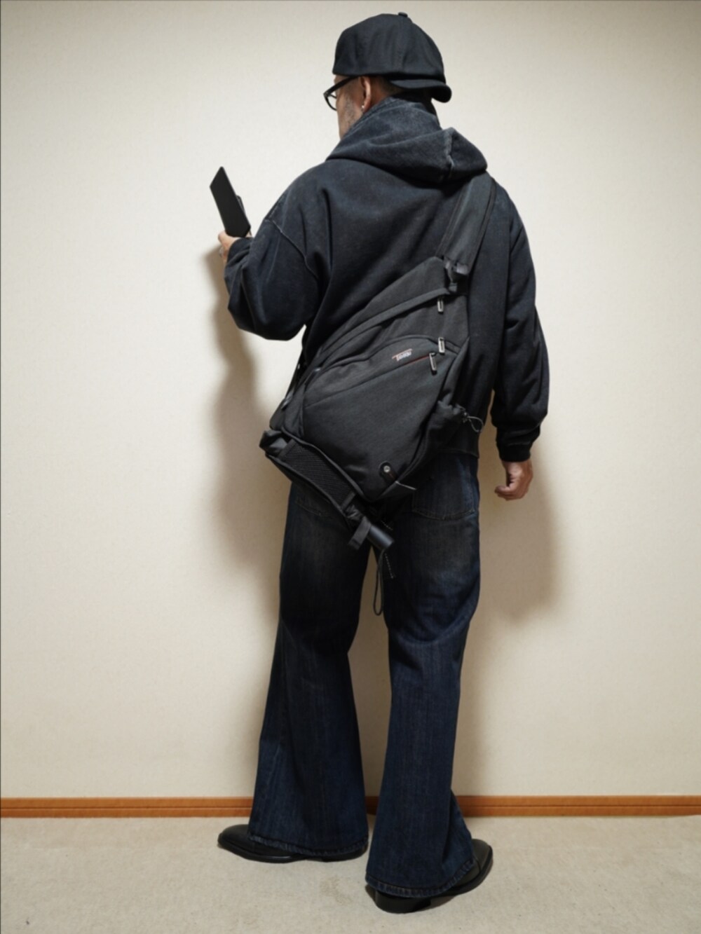 ブラック系のドレスシューズ、ブルー系のデニムパンツ、ブラック系のパーカーを着用したメンズの冬コーディネートの3枚目の写真