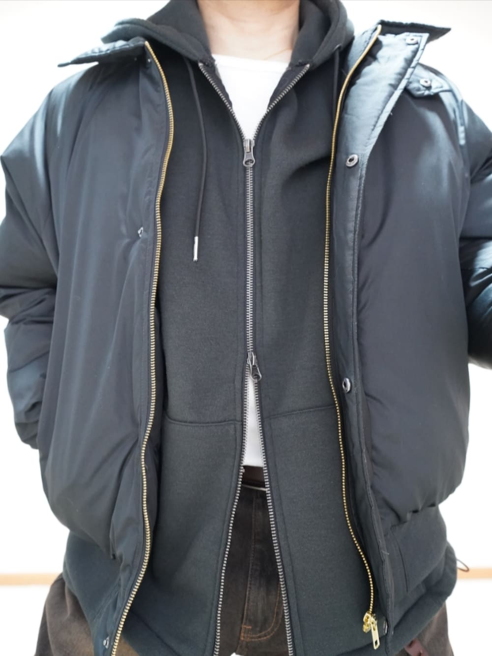 ブラック系のシューズ、ブラック系のデニムパンツ、ブラック系のパーカーを着用したメンズの春コーディネートの4枚目の写真