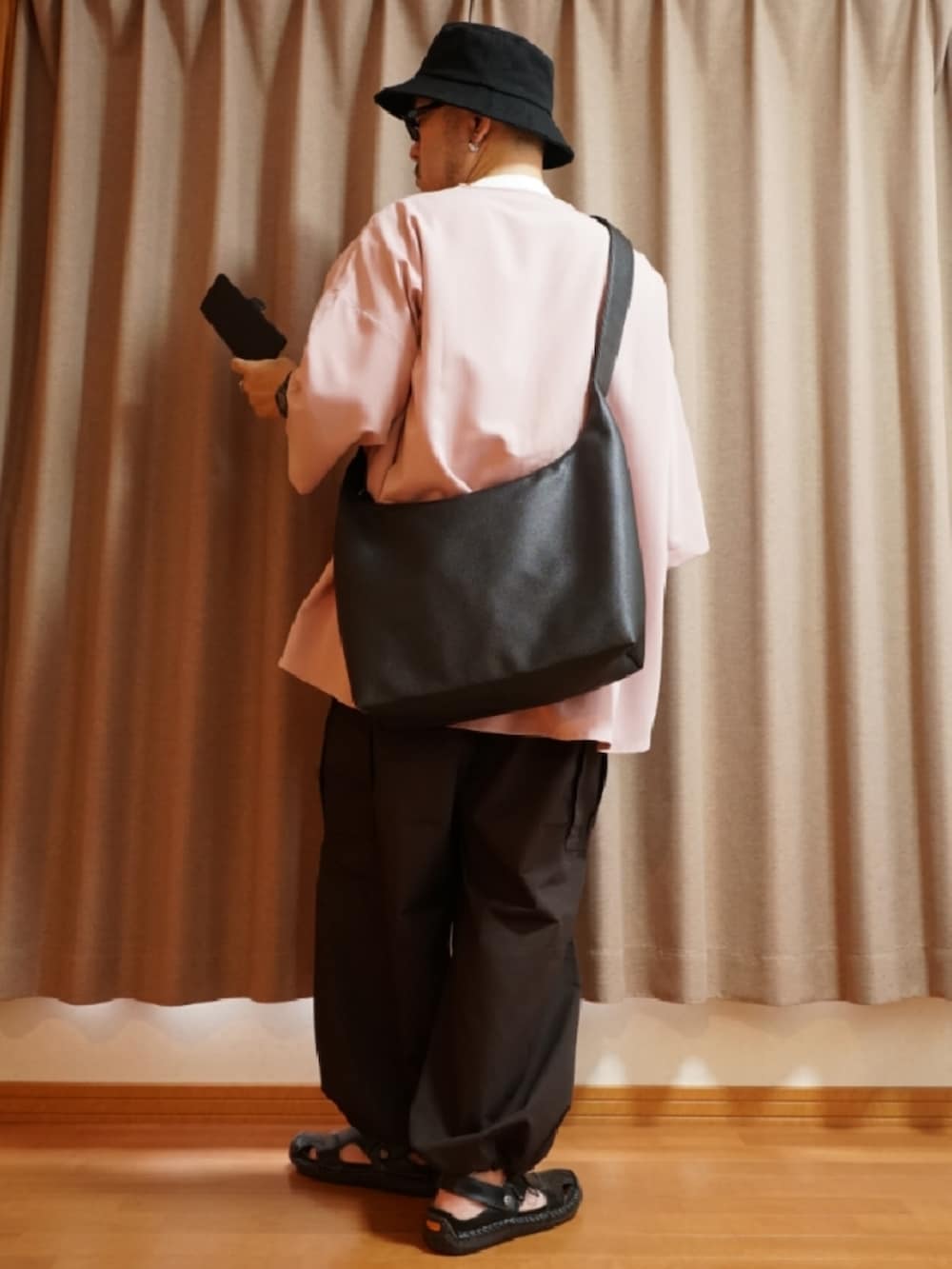 ブラック系のサンダル、ブラウン系のパンツ、ピンク系のシャツ/ブラウスを着用したメンズの夏コーディネートの3枚目の写真