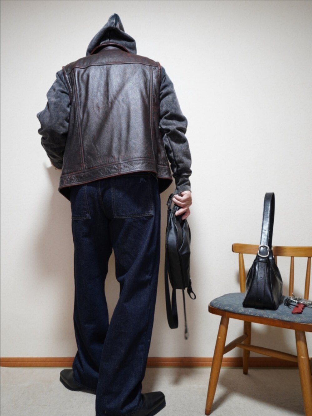 ブラック系のブーツ、ブルー系のデニムパンツ、ブラック系のパーカーを着用したメンズの春コーディネートの4枚目の写真