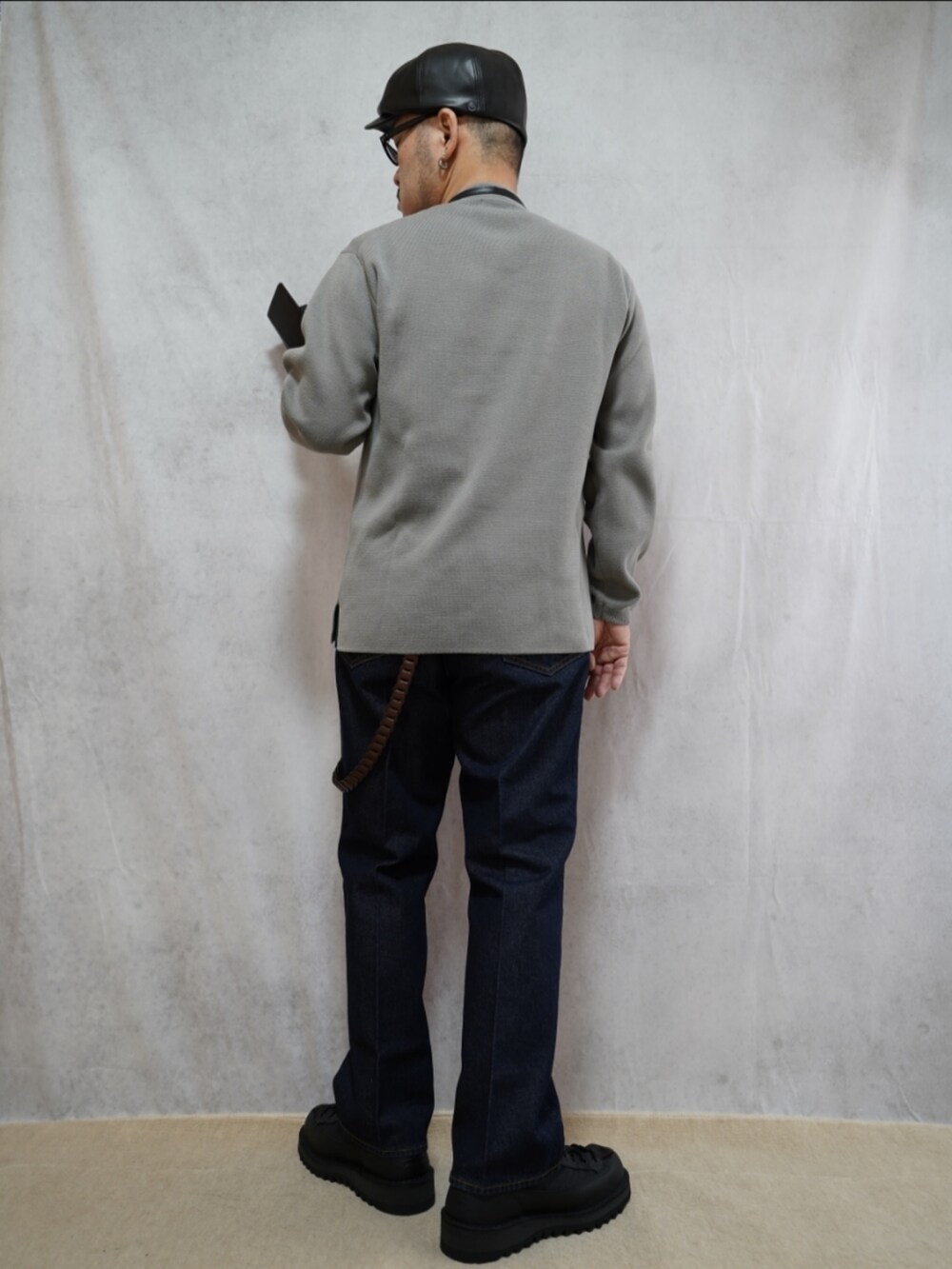 ブラック系のシューズ、ブルー系のデニムパンツ、ブラック系のショルダーバッグを着用したメンズの春コーディネートの3枚目の写真