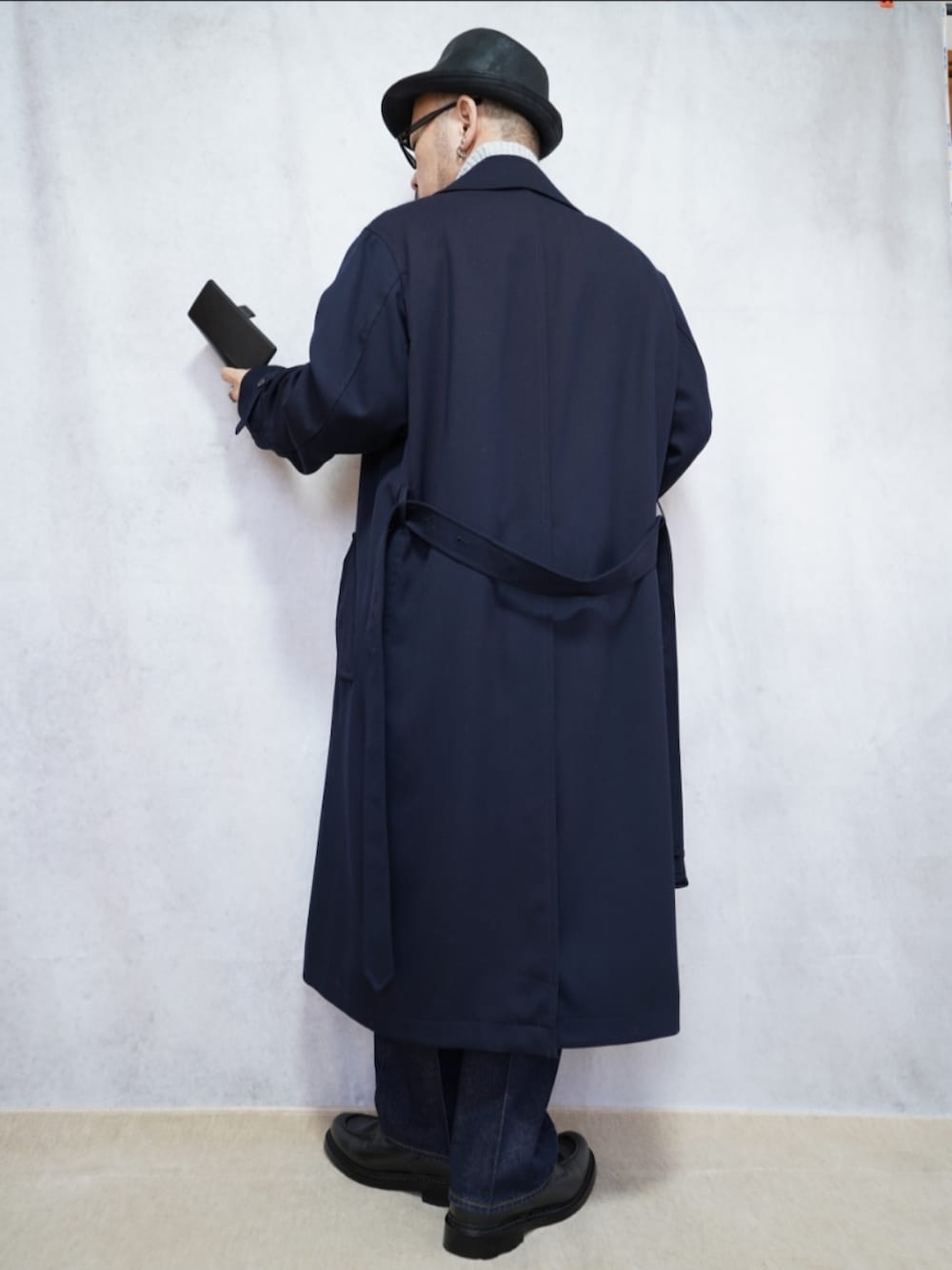 ブラック系のシューズ、ブルー系のデニムパンツ、ブルー系のトレンチコートを着用したメンズの冬コーディネートの3枚目の写真