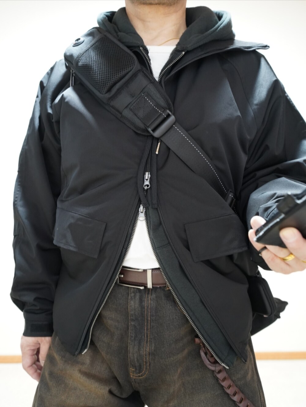 ブラック系のシューズ、ブラック系のデニムパンツ、ブラック系のパーカーを着用したメンズの春コーディネートの4枚目の写真