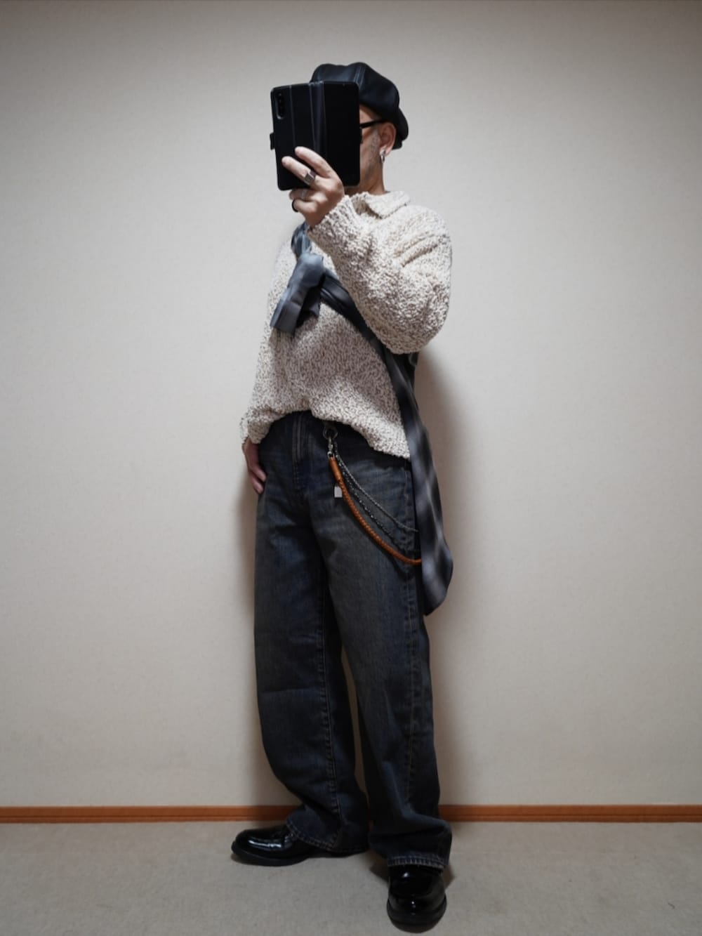 ブラック系のシューズ、ブルー系のデニムパンツ、ホワイト系のニット/セーターを着用したメンズの春コーディネートの3枚目の写真