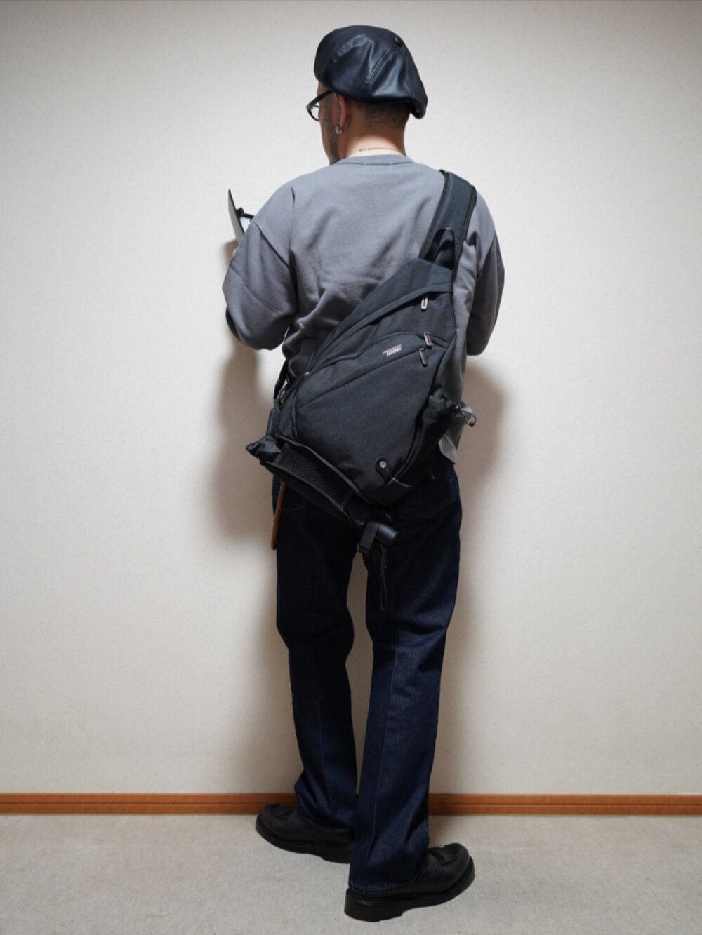 ブラック系のシューズ、ブルー系のデニムパンツ、グレー系のトップスを着用したメンズの春コーディネートの4枚目の写真