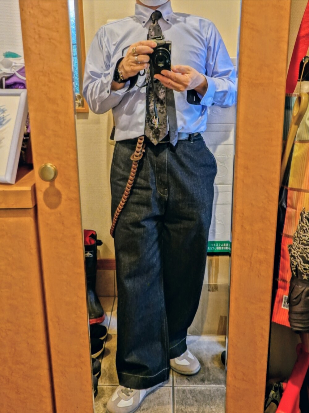 ホワイト系のスニーカー、ブルー系のデニムパンツ、ブラック系のネクタイを着用したメンズの春コーディネートの4枚目の写真