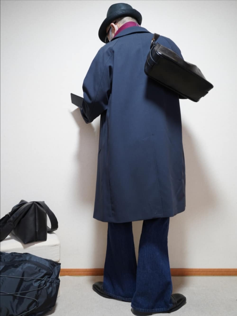 ブラック系のドレスシューズ、ブルー系のデニムパンツ、ブルー系のステンカラーコートを着用したメンズの春コーディネートの4枚目の写真