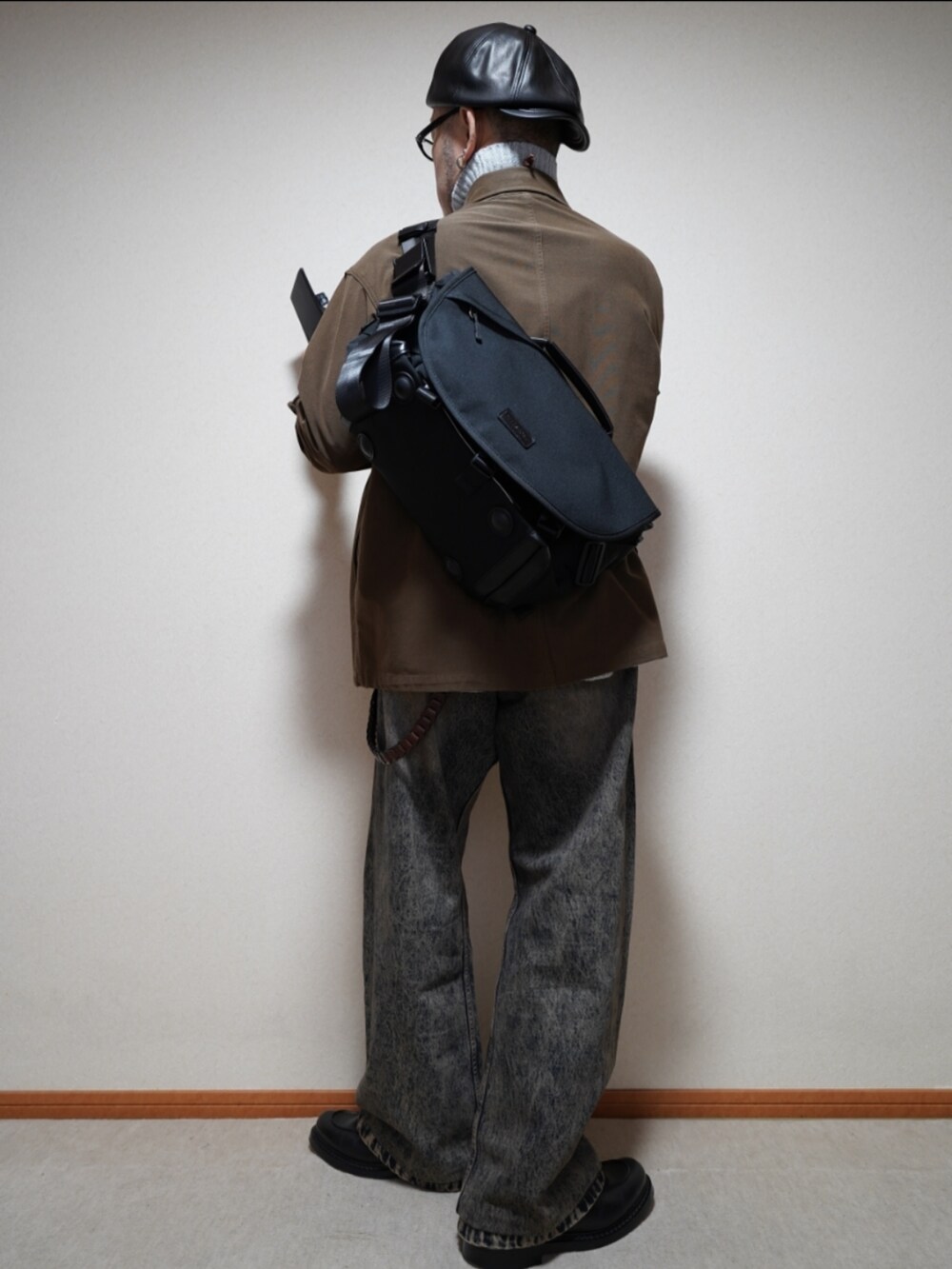 ブラック系のシューズ、ブルー系のデニムパンツ、グレー系のトップスを着用したメンズの冬コーディネートの3枚目の写真