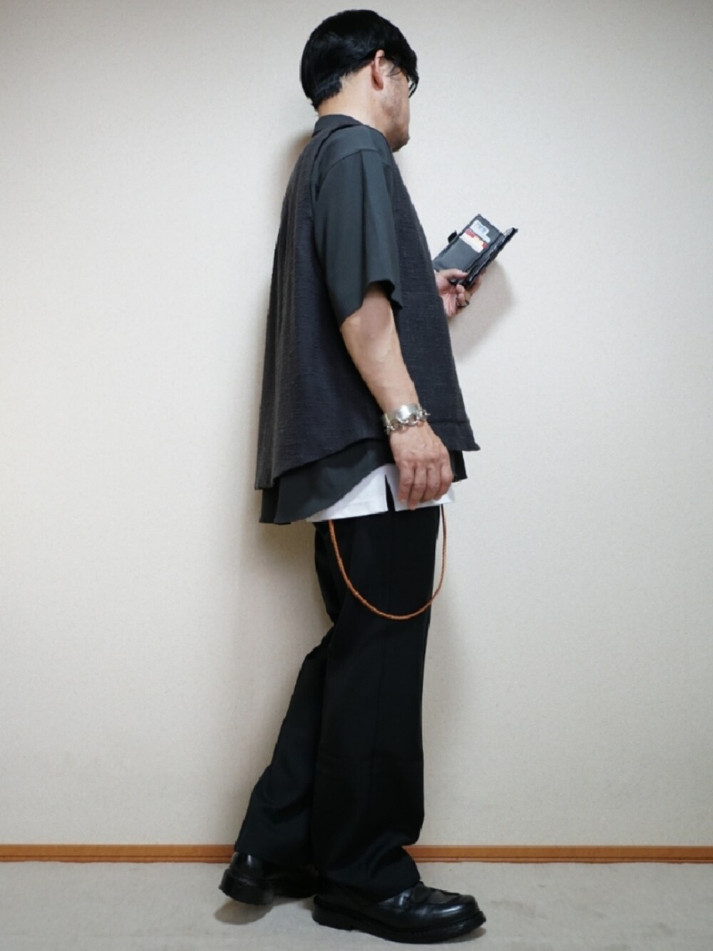 ブラック系のシューズ、ブラック系のパンツ、ホワイト系のタンクトップを着用したメンズの夏コーディネートの4枚目の写真