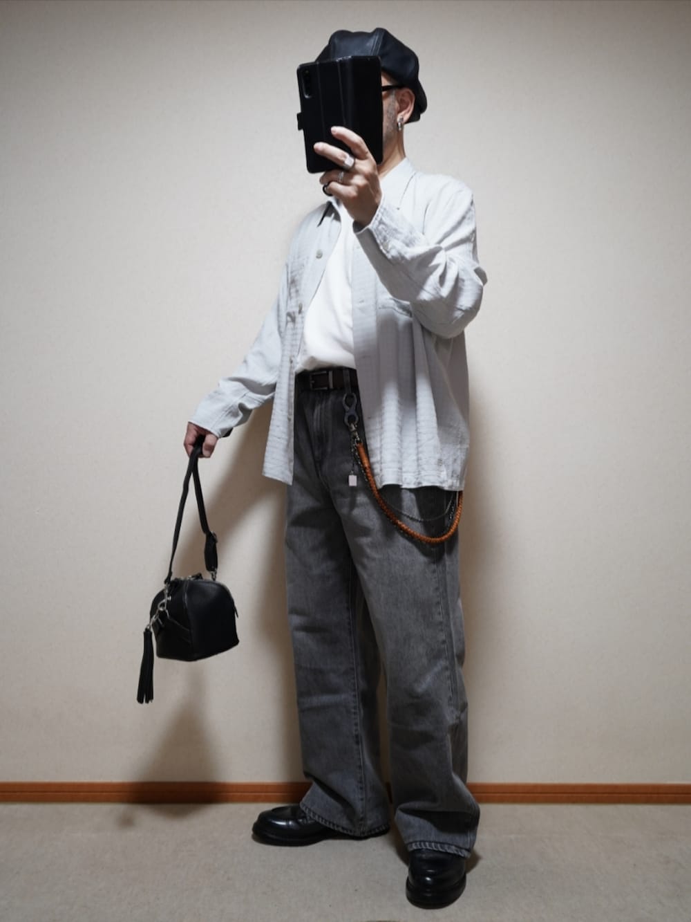 ブラック系のシューズ、グレー系のデニムパンツ、ブラック系のショルダーバッグを着用したメンズの春コーディネートの2枚目の写真