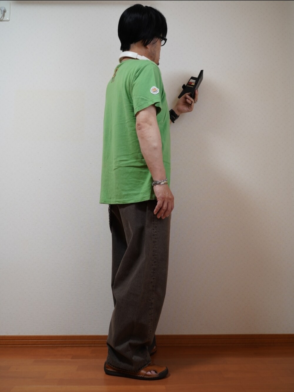 ブラック系のサンダル、ブラウン系のデニムパンツ、グリーン系のTシャツ/カットソーを着用したメンズの夏コーディネートの5枚目の写真