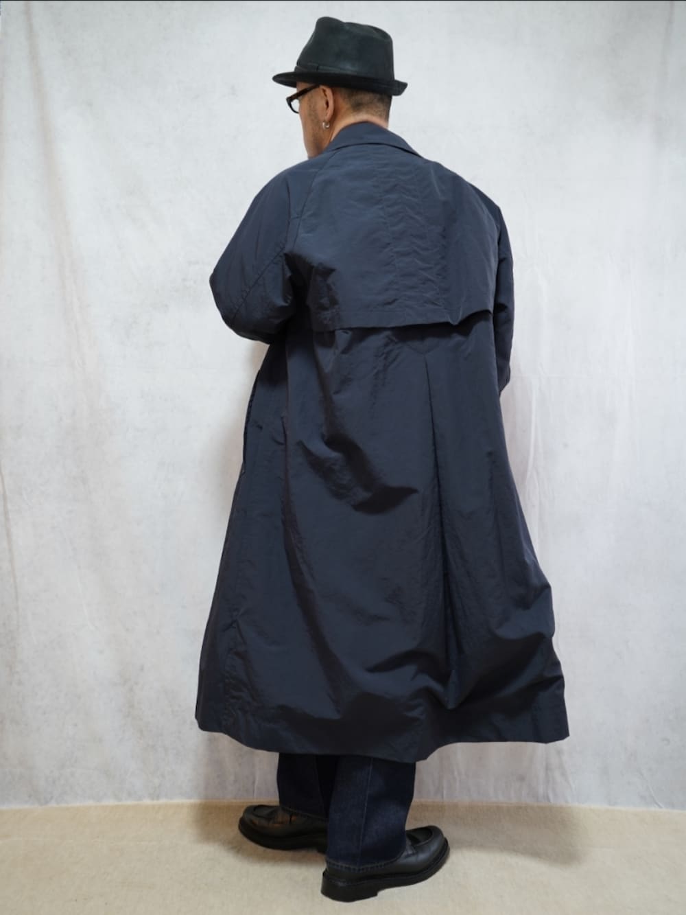 ブラック系のシューズ、ブルー系のデニムパンツ、グレー系のニット/セーターを着用したメンズの冬コーディネートの3枚目の写真