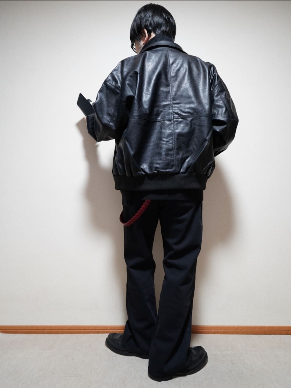 ブラック系のシューズ、グレー系のデニムパンツ、ブラック系のブルゾンを着用したメンズの冬コーディネートの4枚目の写真