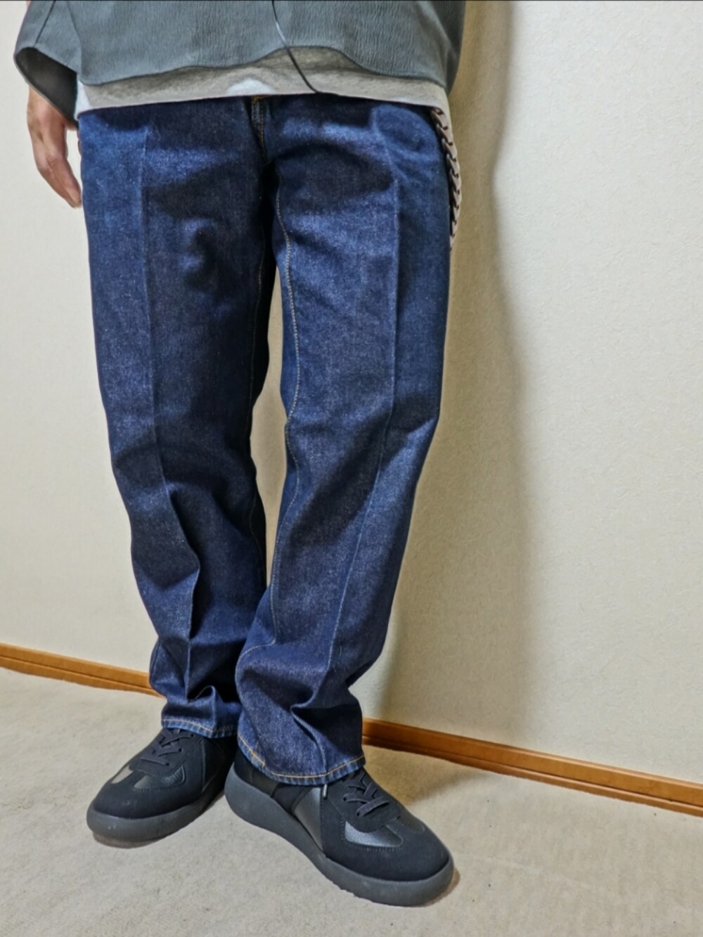 ブラック系のスニーカー、ブルー系のデニムパンツ、グレー系のタンクトップを着用したメンズの夏コーディネートの5枚目の写真