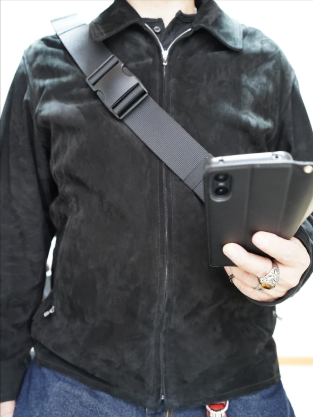 ブラック系のドレスシューズ、ブルー系のデニムパンツ、ブラック系のブルゾンを着用したメンズの春コーディネートの3枚目の写真