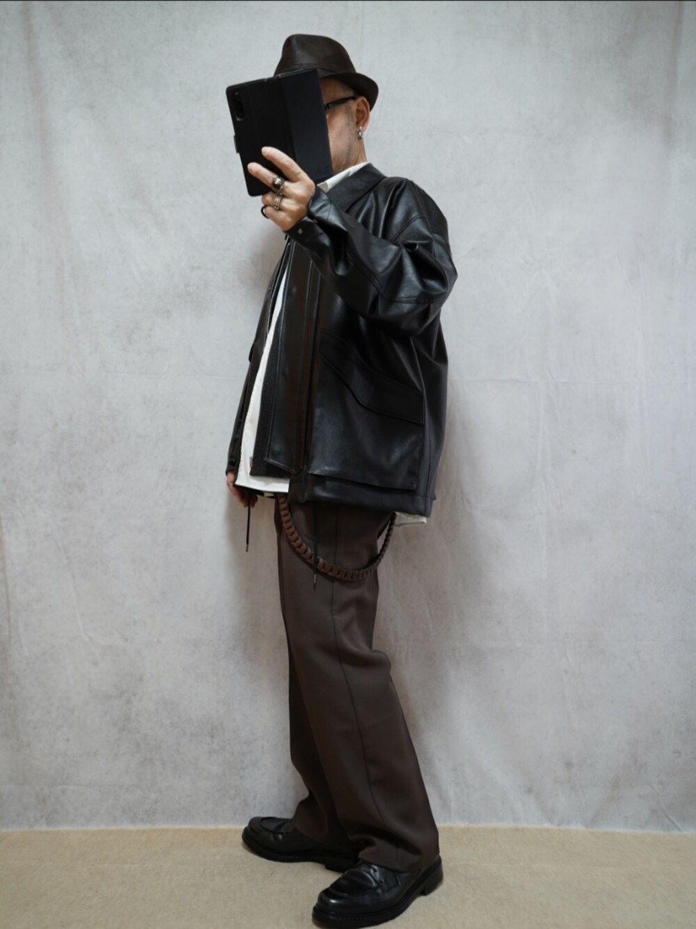 ブラック系のシューズ、ブラウン系のパンツ、ホワイト系のシャツ/ブラウスを着用したメンズの冬コーディネートの2枚目の写真